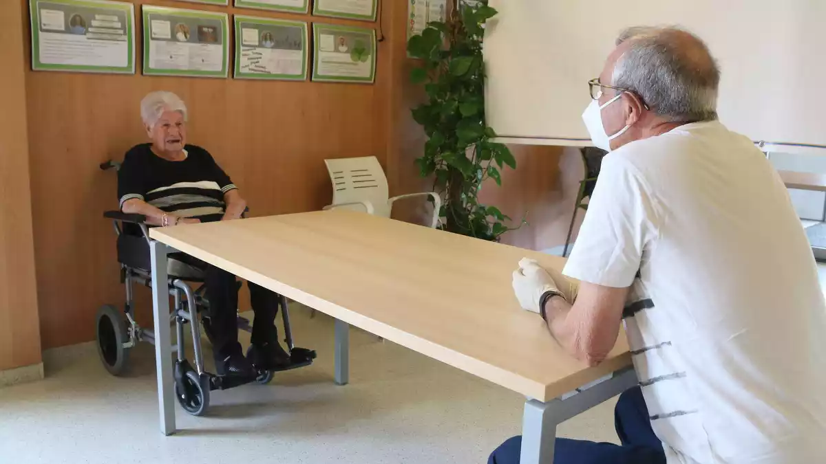 Pla mitjà de Salvador Plana conversant amb la seva mare, de 102 anys, a la residència STS Misericòrdia de Reus.