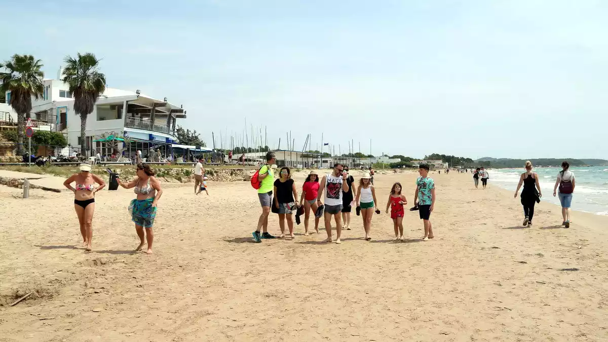 Un grup de persones passejant a la platja Llarga de Tarragona en l'últim dia de la fase 1