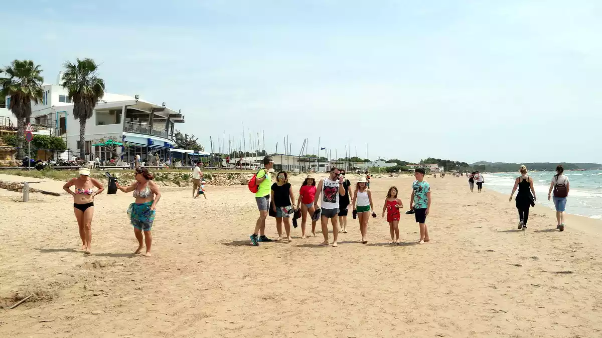 Un grup de persones passejant a la platja Llarga de Tarragona en l'últim dia de la fase 1