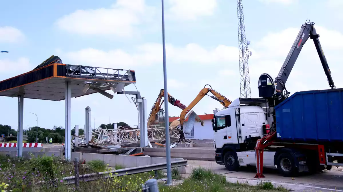 Pla general de camions i màquines treballant en les obres de retirada de les estructures del peatge de l'Aldea de l'AP-7