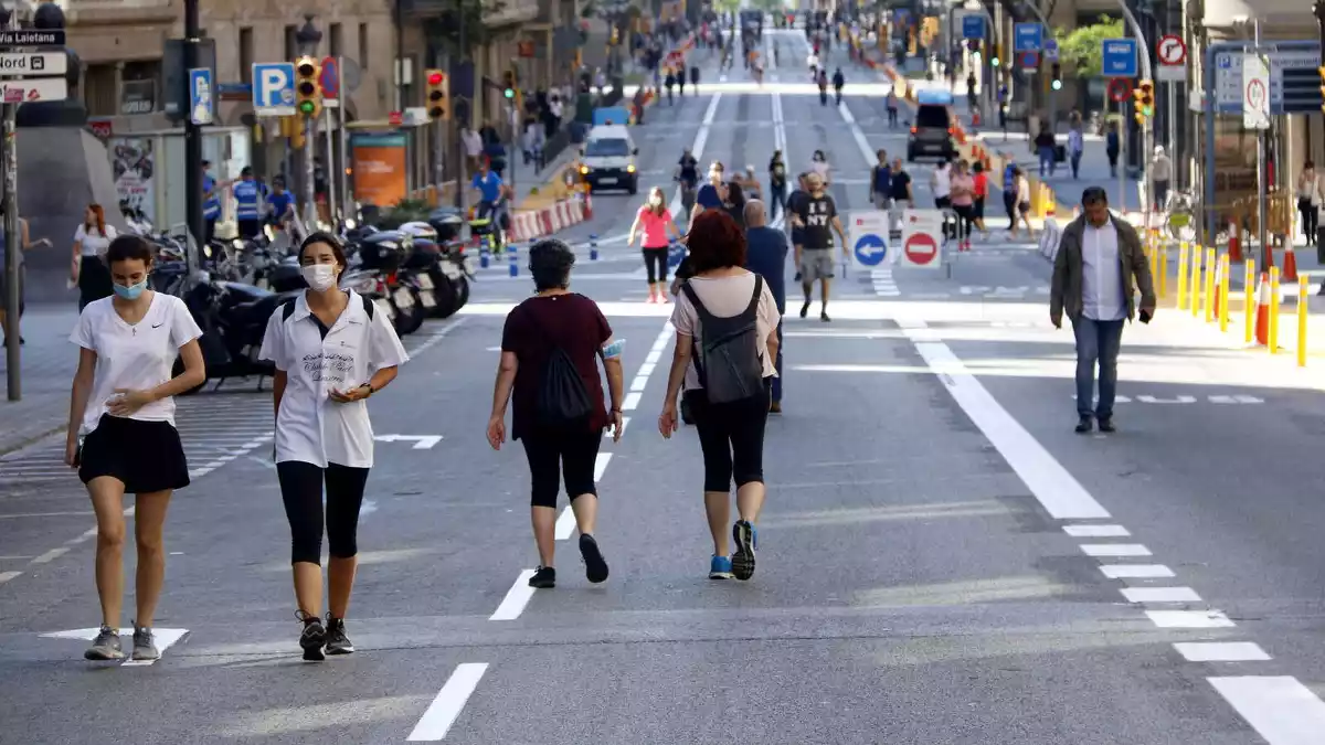 Ciutadans passejant per Via Laietana amb distància de seguretat pel coronavirus, tallada al trànsit, 23/05/2020