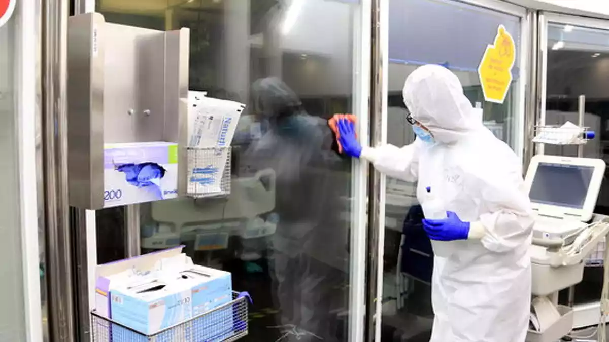 Una professional sanitària neteja els vidres d'una UCI amb pacients amb covid-19 a l'Hospital del Mar, el 15 d'abril del 2020