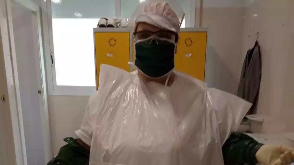 L'auxiliar d'infermeria Janira Garcia, amb una bossa de la brossa com a protecció contra el coronavirus