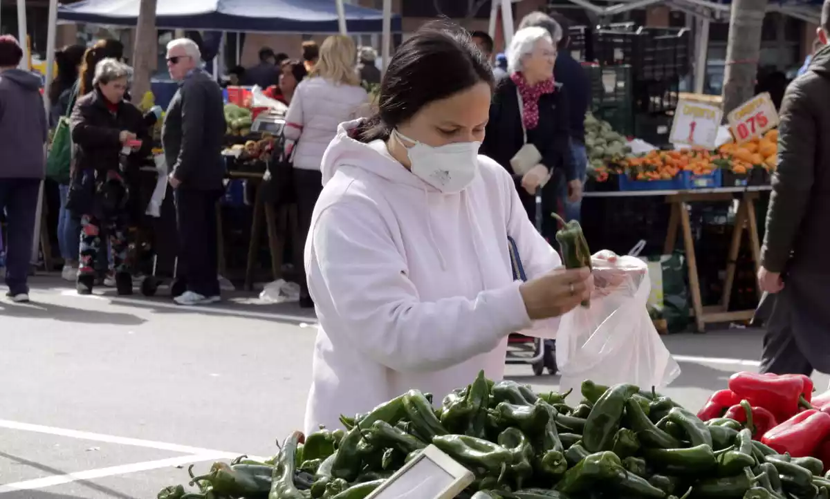 Pla mitjà d'una compradora amb mascareta al mercat dels dissabtes de Lleida