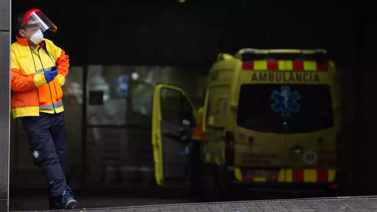 Sanitari esperant a l'entrada de l'Hospital Sant Pau de Barcelona al costat d'una ambulància , 5 d'abril de 2020