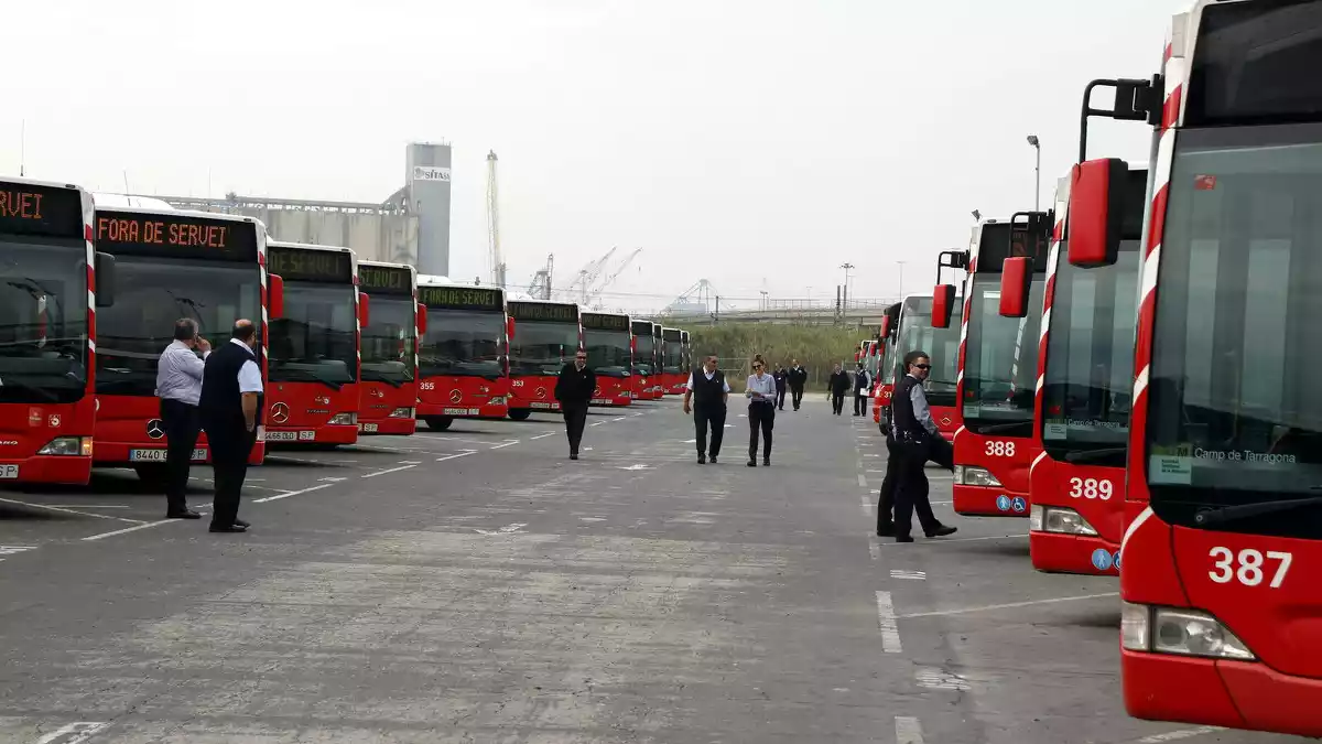 Pla obert de desenes d'autobusos a cotxeres, amb diversos treballadors de l'EMT de Tarragona davant
