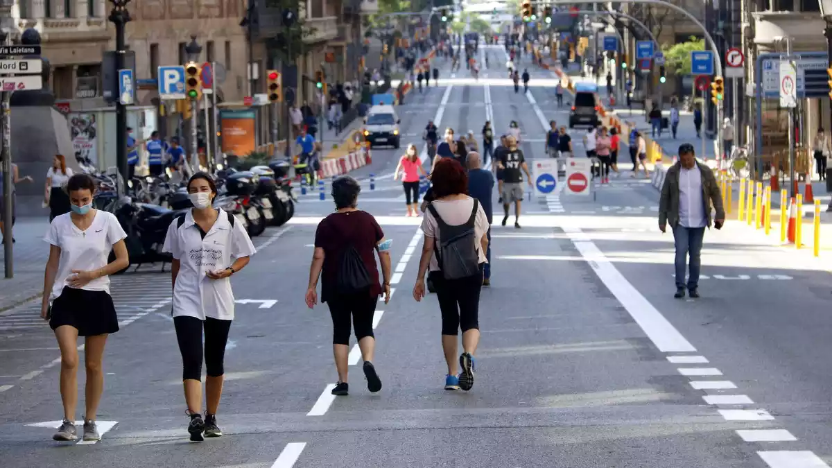 Ciutadans passejant per Via Laietana amb distància de seguretat pel coronavirus, tallada al trànsit, 23/05/2020