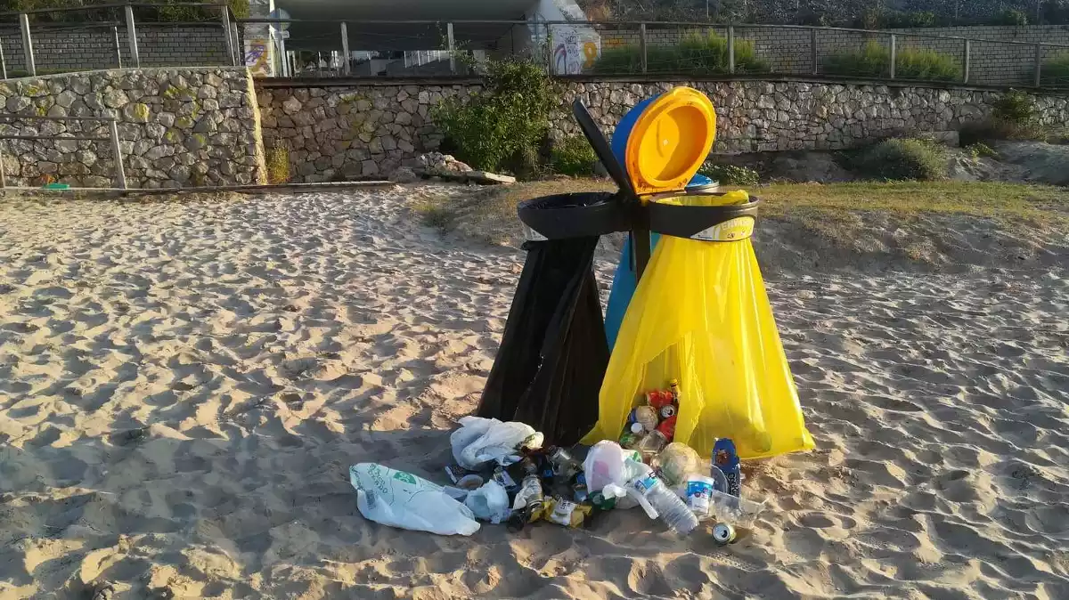 Pla detall d'una paperera punxada a la platja de Tarragona