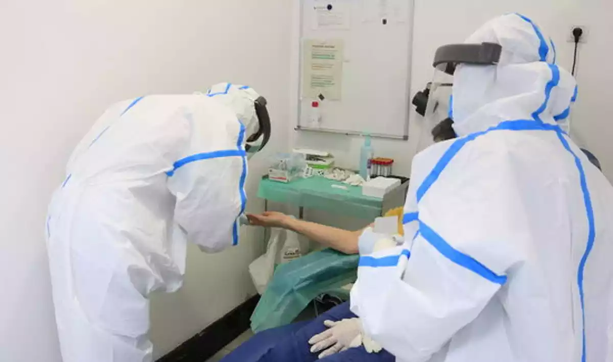 Professionals del CAP Manso, amb equip de protecció individual (EPI), en el moment d'extreure una mostra de sang amb una punxada al dit a una participant a l'estudi de seroprevalença del coronavirus a nivell estatal. 30 d'abril del 2020.