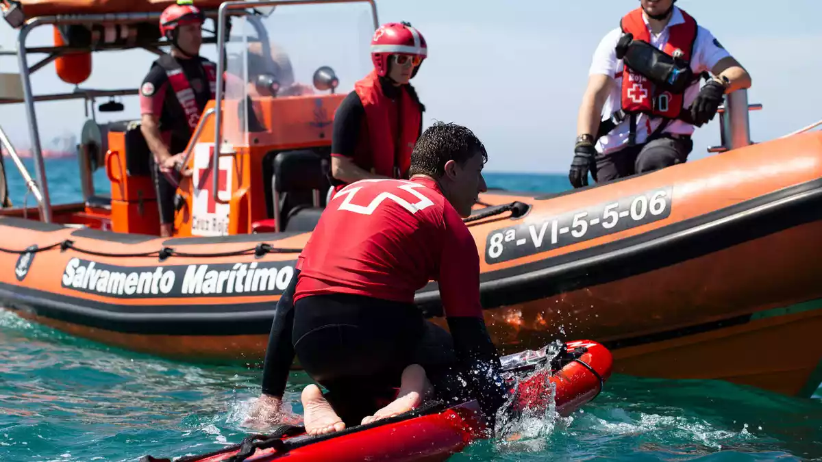 Pla obert d'un dels aspirants dins l'aigua fent una de les proves de selecció de la Creu Roja per ser socorrista.